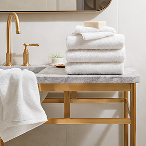 H by Frette Towel Set in White Folded on Counter of Bathroom